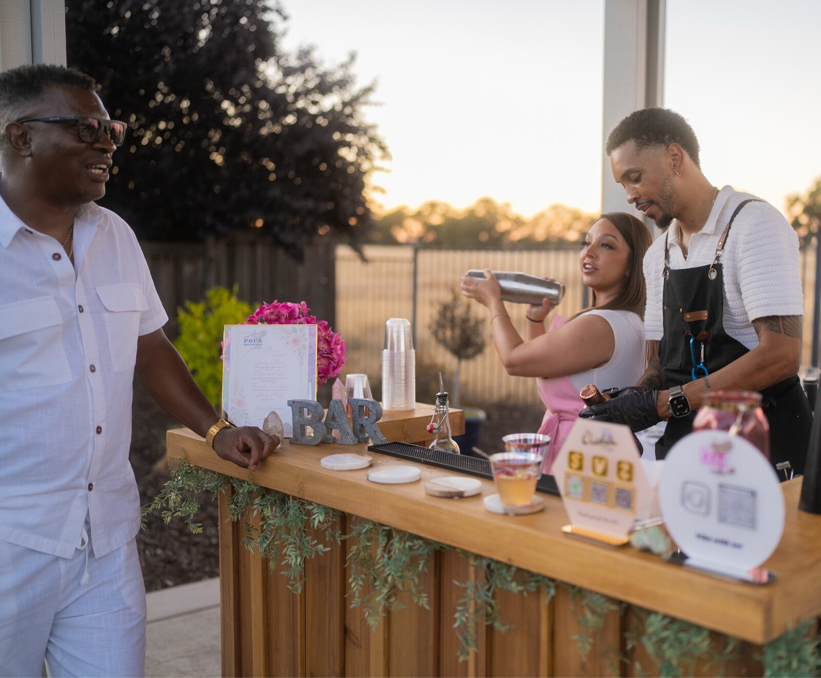 Tyler and Jacque serving guests together from the 916 Pour Decisions mobile bar at an outdoor event.